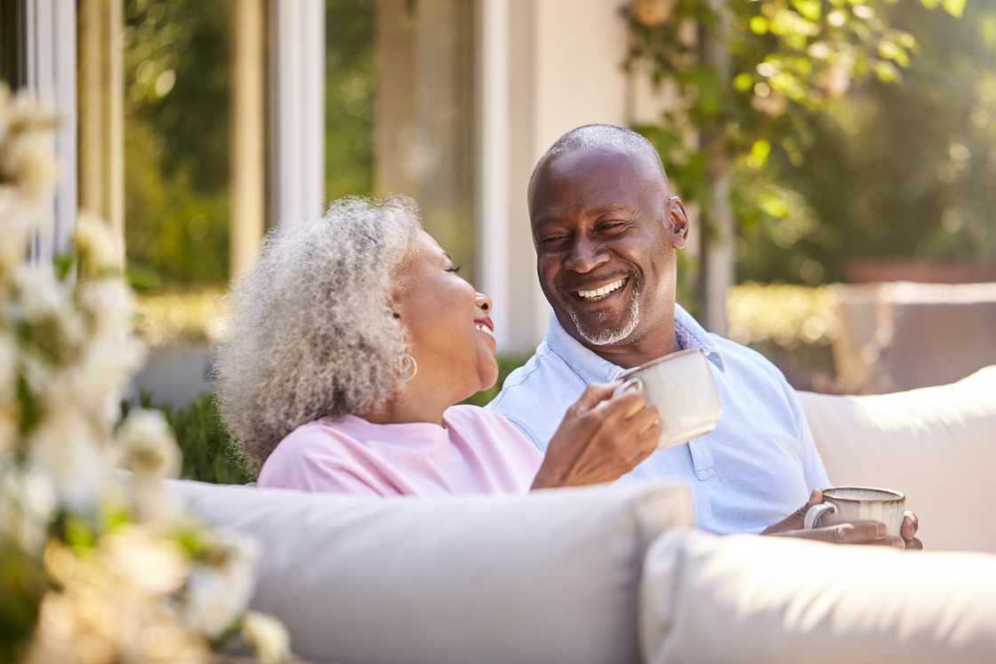 A man and woman sitting outdoors having coffee