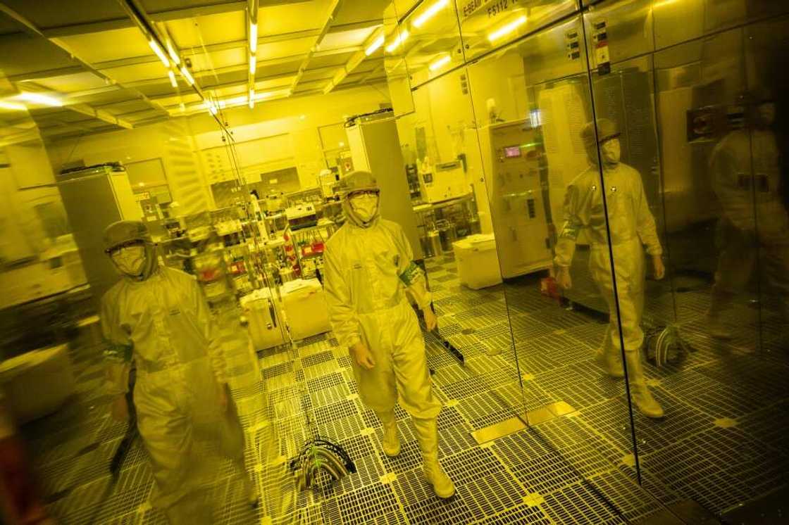 This picture taken on May 1, 2024 shows Tokyo University PhD student Kei Misumi (L) working in a clean room at the University of Tokyo