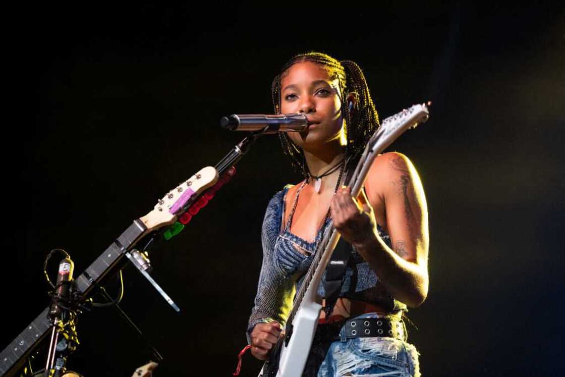 Singer Willow performs onstage with a guiter