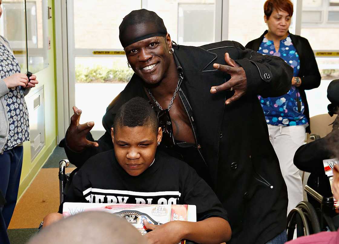 Wrestler R-Truth posing for a photo with a kid