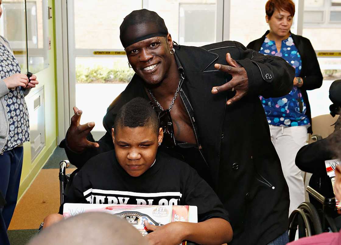 Wrestler R-Truth posing for a photo with a kid Wrestler R-Truth posing for a photo with a kid