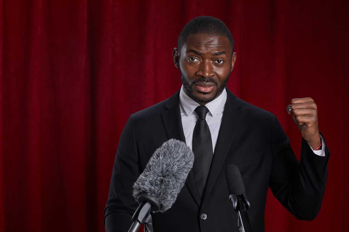 A young man at the pulpit speaking into a microphone.