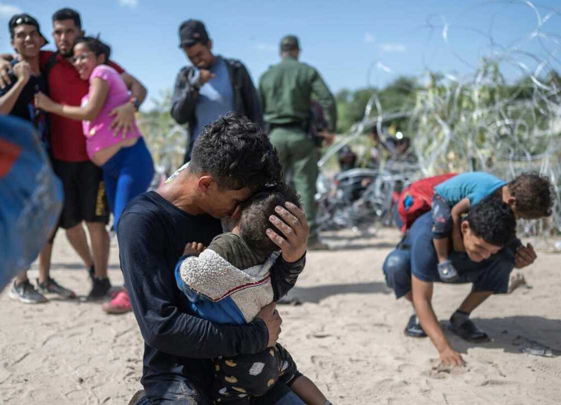 A migrant family from Venezuela breaks through a razor wire barricade into the United States on the Rio Grande river in Eagle Pass, Texas, on September 25, 2023 A migrant family from Venezuela breaks through a razor wire barricade into the United States on the Rio Grande river in Eagle Pass, Texas, on September 25, 2023