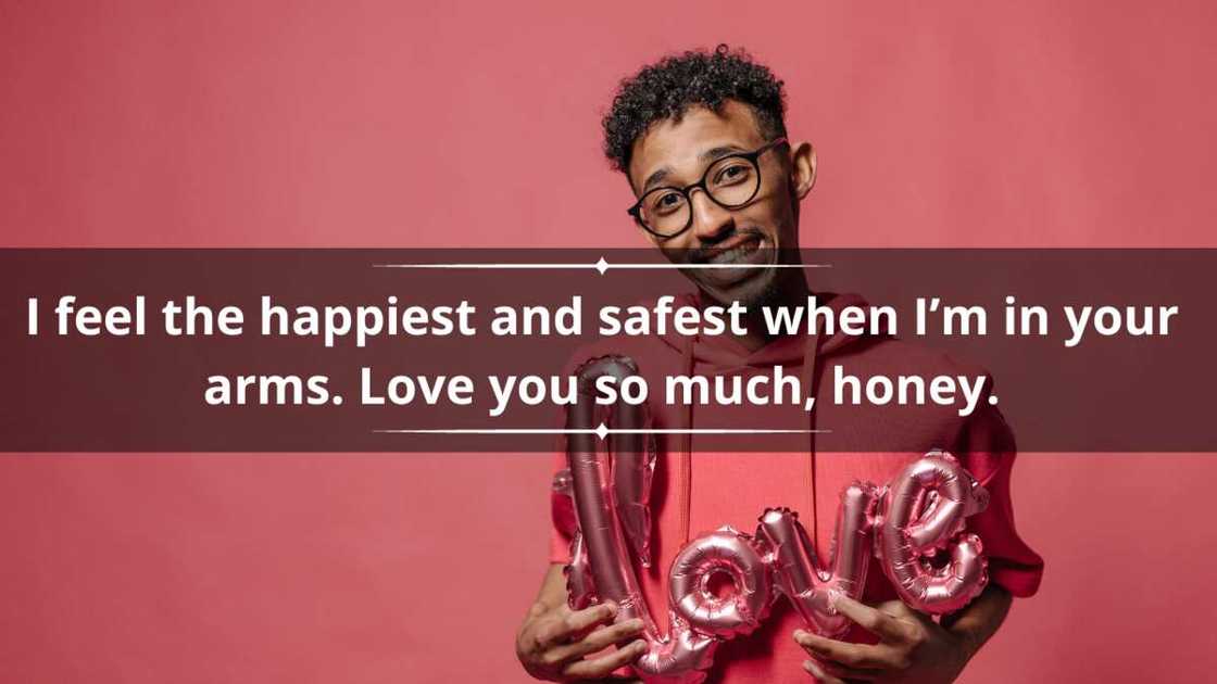 A man in a pink hoodie is holding a love balloon A man in a pink hoodie is holding a love balloon