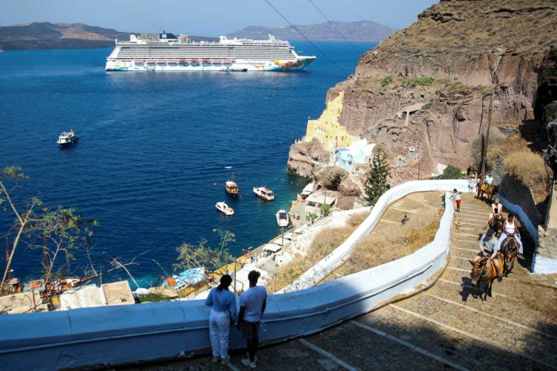A cruise ship off the Greek island of Santorini, which is among the destinations for which cruise ships will now pay tourist taxes A cruise ship off the Greek island of Santorini, which is among the destinations for which cruise ships will now pay tourist taxes
