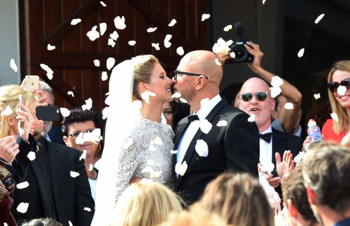 Le chanteur français Pascal Obispo (à droite) et la mannequin Julie Hantson s'embrassent devant l'église du Cap Ferret après leur mariage le 19 septembre 2015.