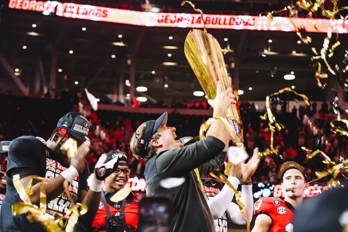 Kirby Smart holds up a trophy. Kirby Smart holds up a trophy.