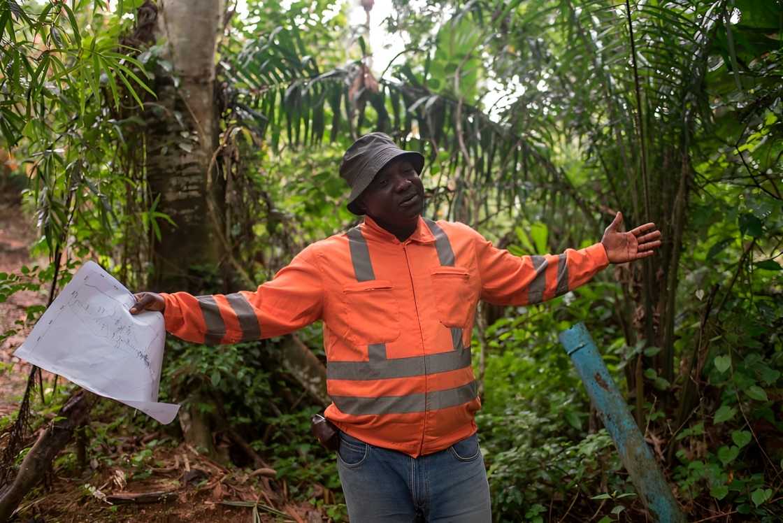 A geophysicist holds a map as he explains the drilling surveys