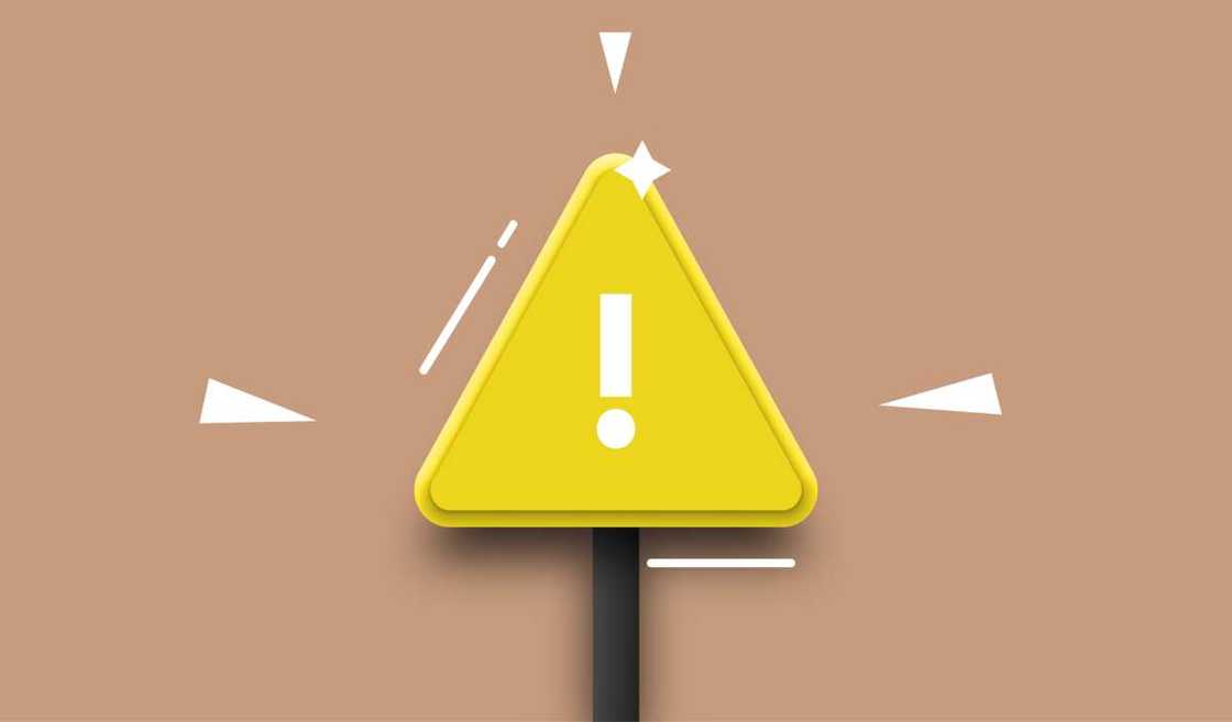 A cut out-paper of a yellow triangle with an exclamation mark A cut out-paper of a yellow triangle with an exclamation mark