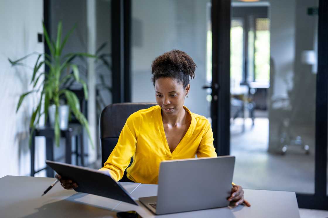 A young woman using a laptop in a modern office. A young woman using a laptop in a modern office.