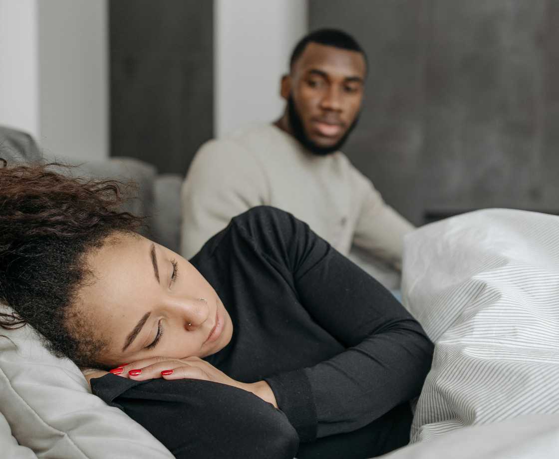 A man looks at his sleeping wife