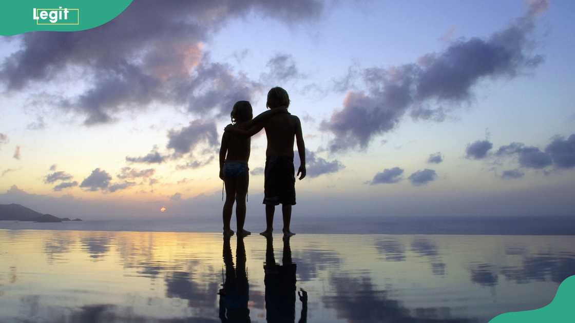 Silhouette of two people holding hands Silhouette of two people holding hands