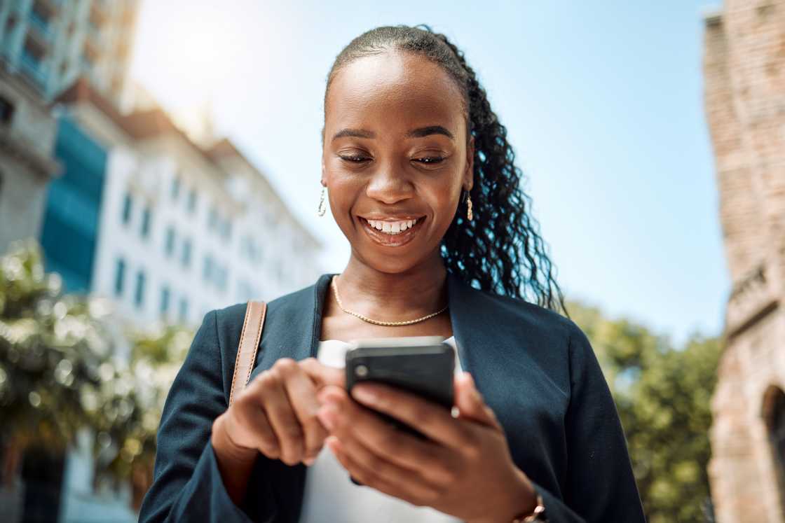 A woman walking in the street while using her phone. A woman walking in the street while using her phone.
