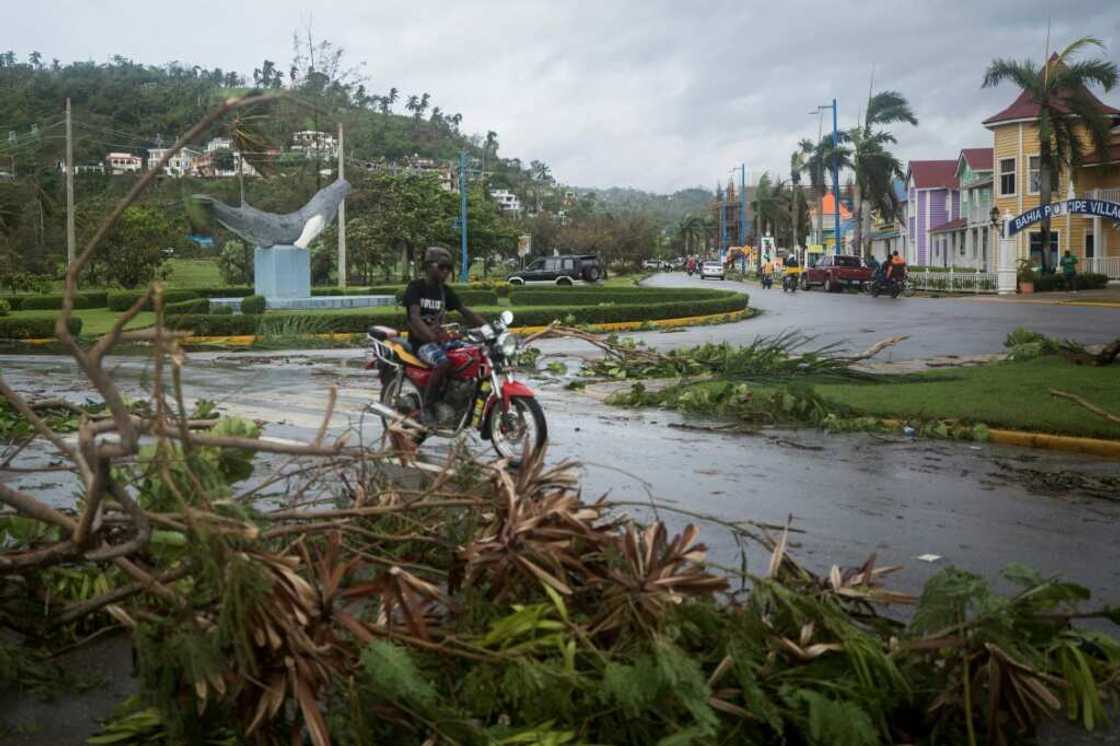 A man rides his motorbike past fallen branches after the passage of Hurricane Fiona, in Samana, Dominican Republic