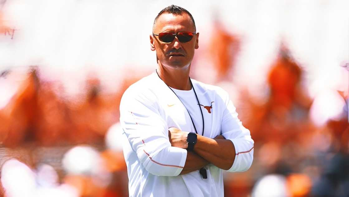 Steve Sarkisian stands on the field