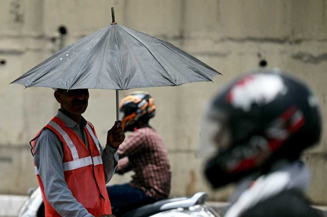 As developing countries urge increases in climate aid, a toll booth worker takes shade under an umbrella during a record heatwave in Delhi As developing countries urge increases in climate aid, a toll booth worker takes shade under an umbrella during a record heatwave in Delhi