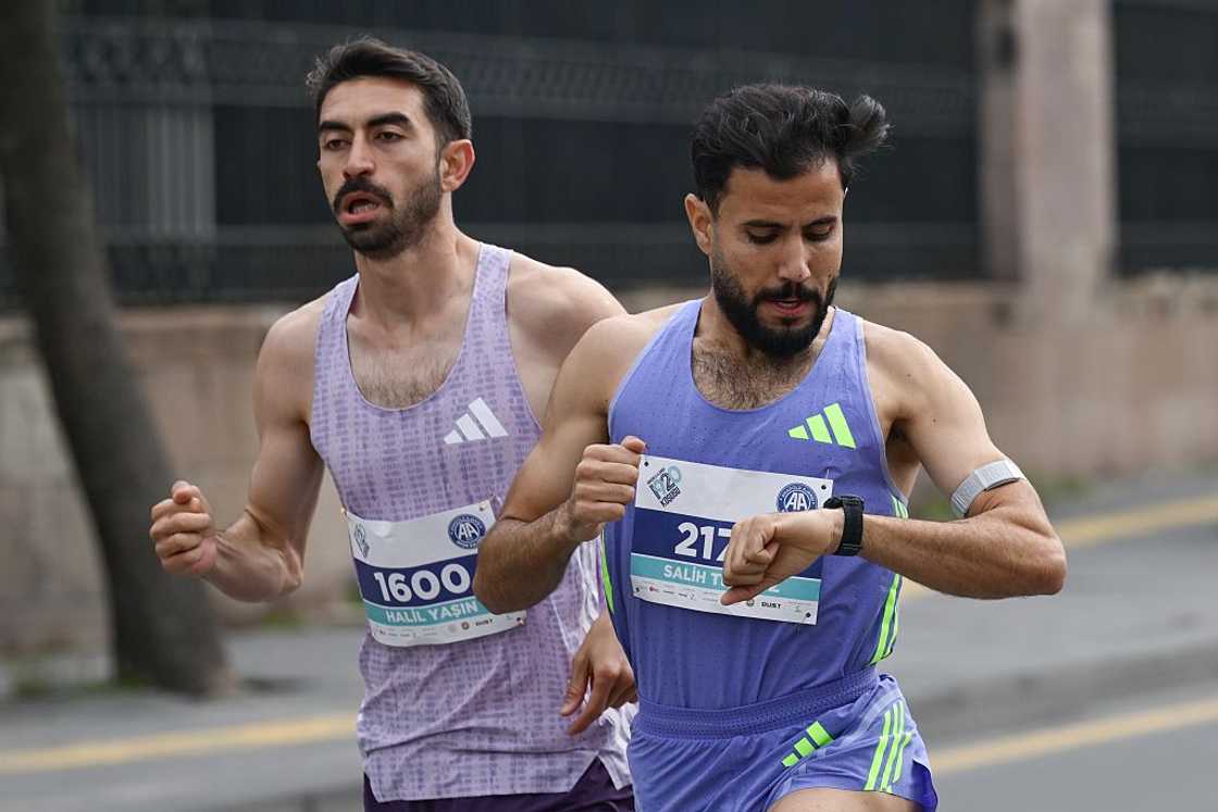 A runner checks a tracking app A runner checks a tracking app