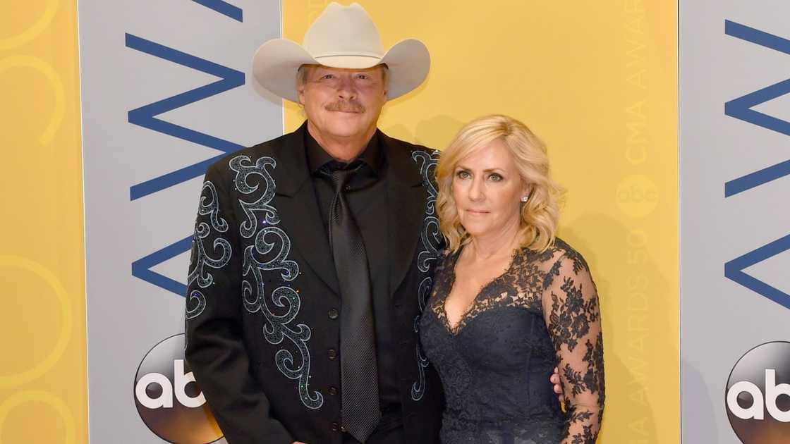 Alan Jackson and his wife, Denise pose standing on the red carpet of the 2016 CMA awards.