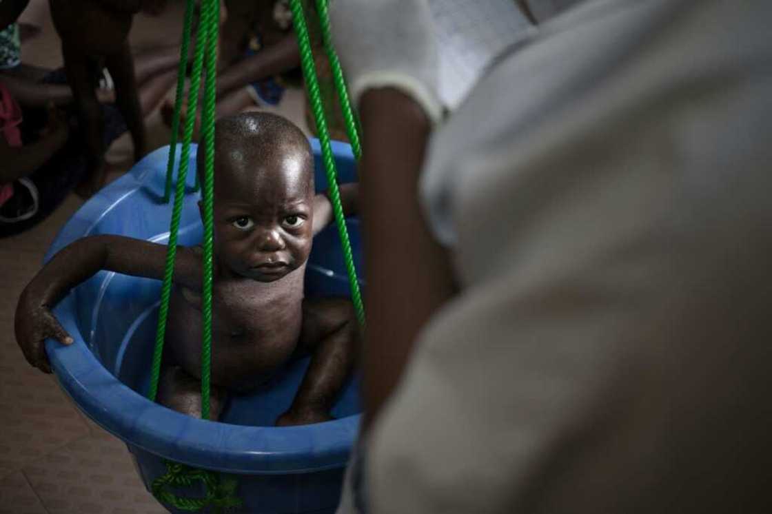 Hunger: A child is weighed at a CAR malnutrition unit