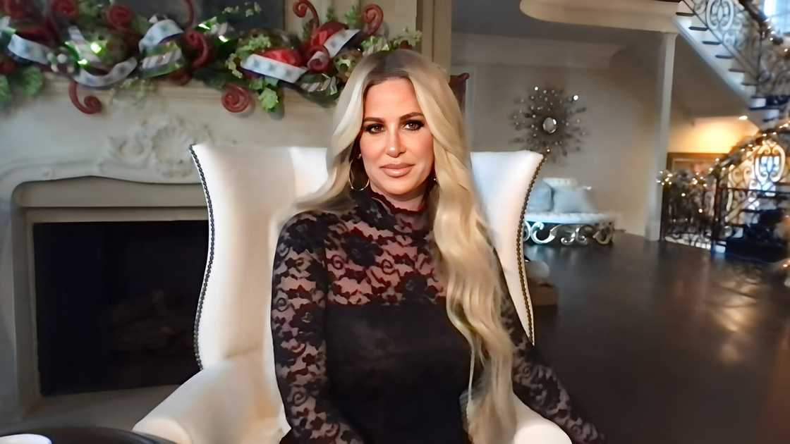 Kim Zolciak-Biermann, seated in her Christmas decorated living room