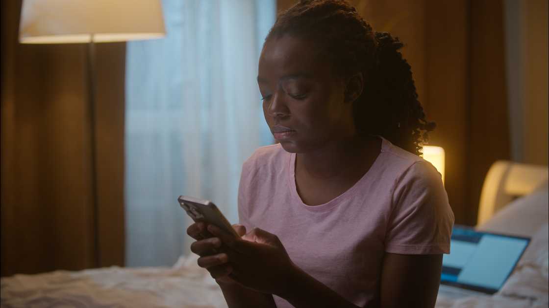 A lady reads a text from her phone A lady reads a text from her phone