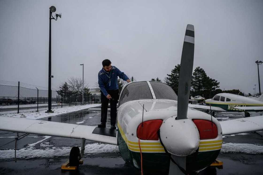 An instructor stands before training aircraft at the Farmingdale State College flying school in Farmingdale, New York An instructor stands before training aircraft at the Farmingdale State College flying school in Farmingdale, New York