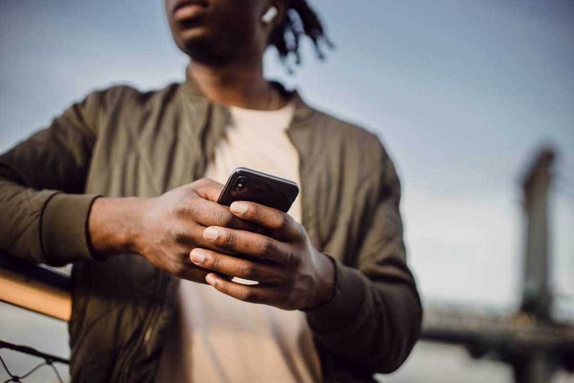 A young man holding their phone A young man holding their phone