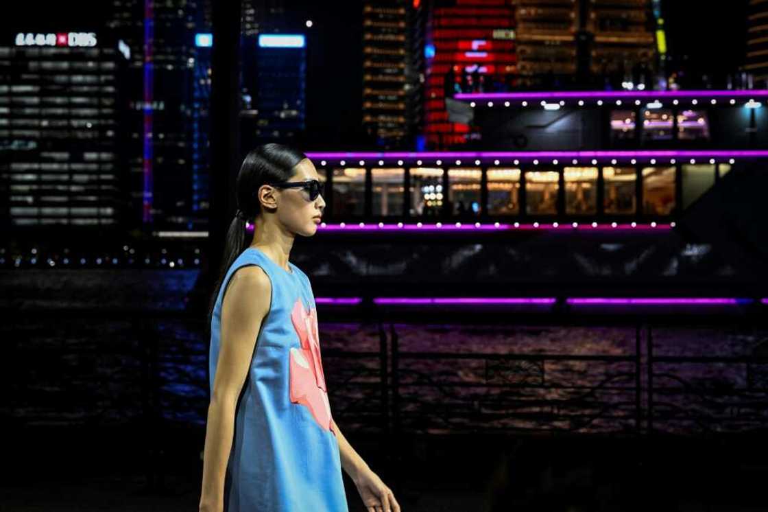 Dozens of models in dark blues and pastels paraded down the riverfront catwalk that took Shanghai's Oriental Pearl Tower as a backdrop Dozens of models in dark blues and pastels paraded down the riverfront catwalk that took Shanghai's Oriental Pearl Tower as a backdrop