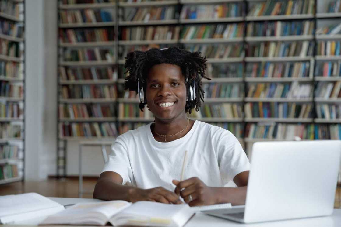 A guy student sit at table in library A guy student sit at table in library