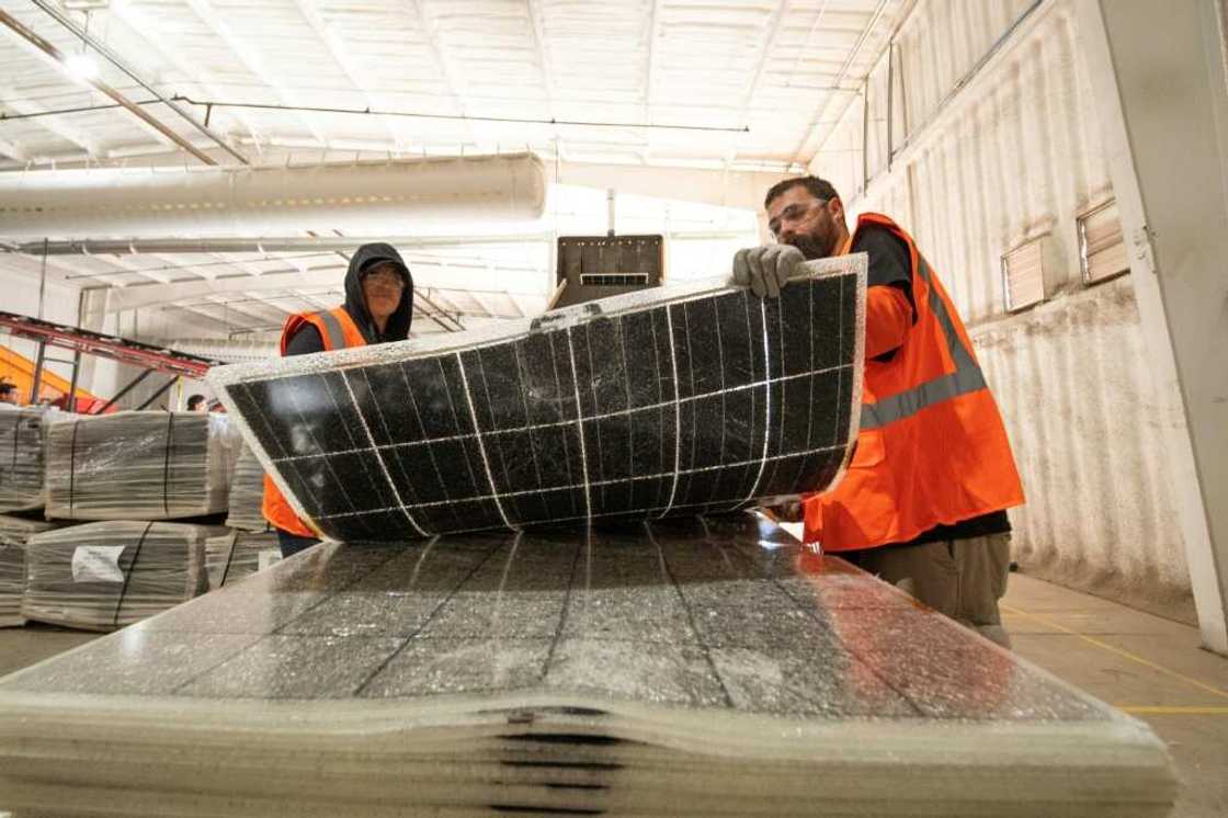 Workers push damaged solar panels into a machine to be recycled at the We Recycle Solar plant in Yuma, Arizona Workers push damaged solar panels into a machine to be recycled at the We Recycle Solar plant in Yuma, Arizona