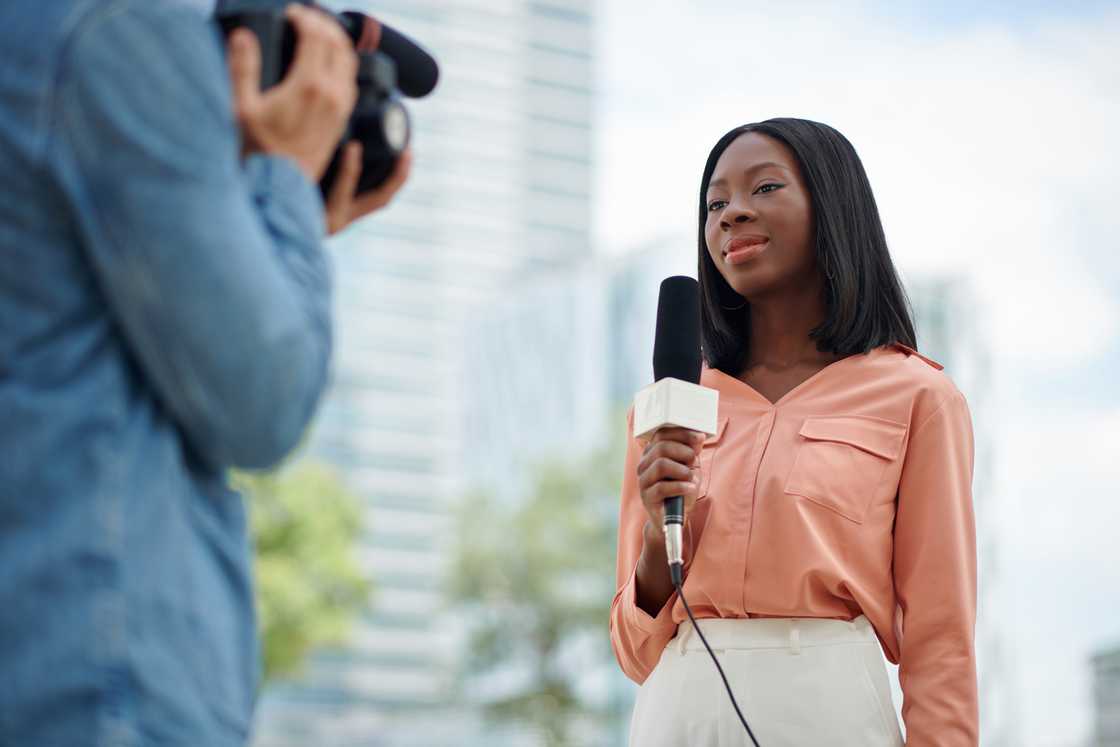 Smiling journalist and cameraman filming a news report Smiling journalist and cameraman filming a news report