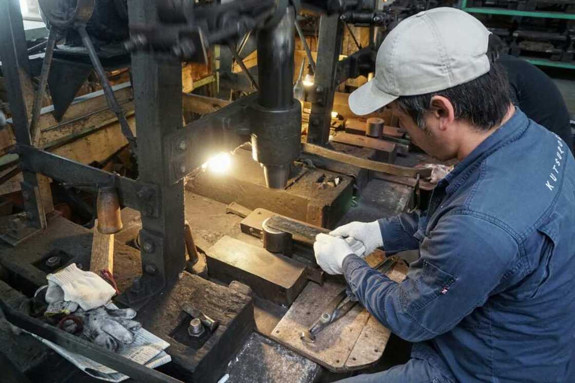 Yoshihiro Yauji places a 'santoku', a multipurpose knife, under a spring hammer, continuing a tradition dating back centuries Yoshihiro Yauji places a 'santoku', a multipurpose knife, under a spring hammer, continuing a tradition dating back centuries