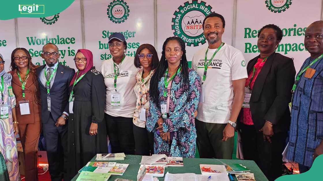A group of NSITF representatives posing for a photo at a public event booth A group of NSITF representatives posing for a photo at a public event booth