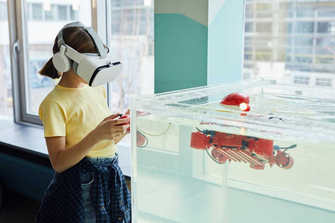 A lady wearing a headset testing a robotic device