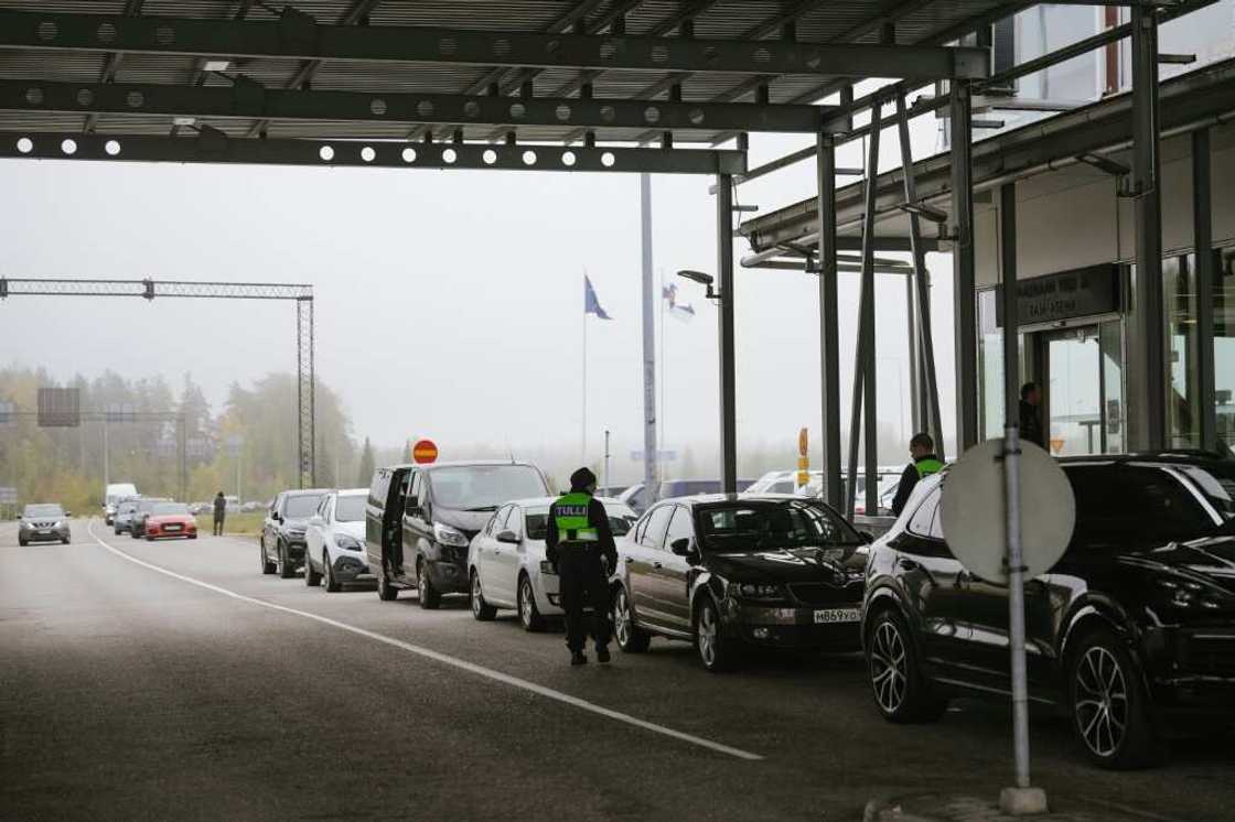 Dozens of cars and buses with Russian licence plates are lined up at the border Dozens of cars and buses with Russian licence plates are lined up at the border