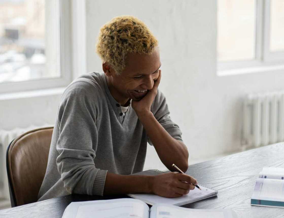 A student writing on a book during a lesson in university