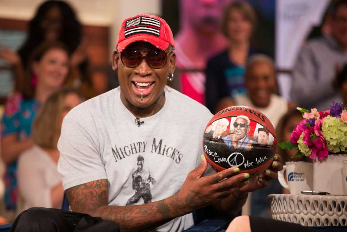 Dennis Rodman poses with a basketball in 2018