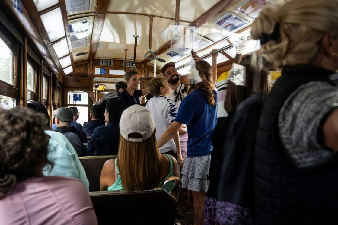 Tourists take selfies inside a tram in Lisbon