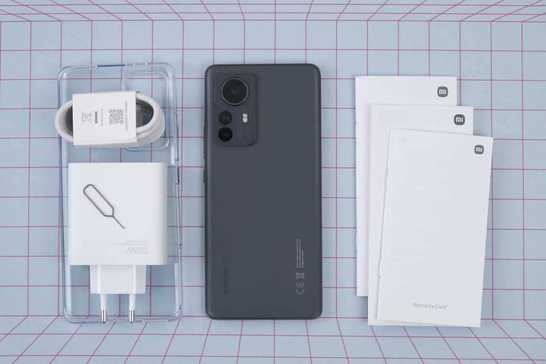 A black Xiaomi 12 Pro with its charger A black Xiaomi 12 Pro with its charger