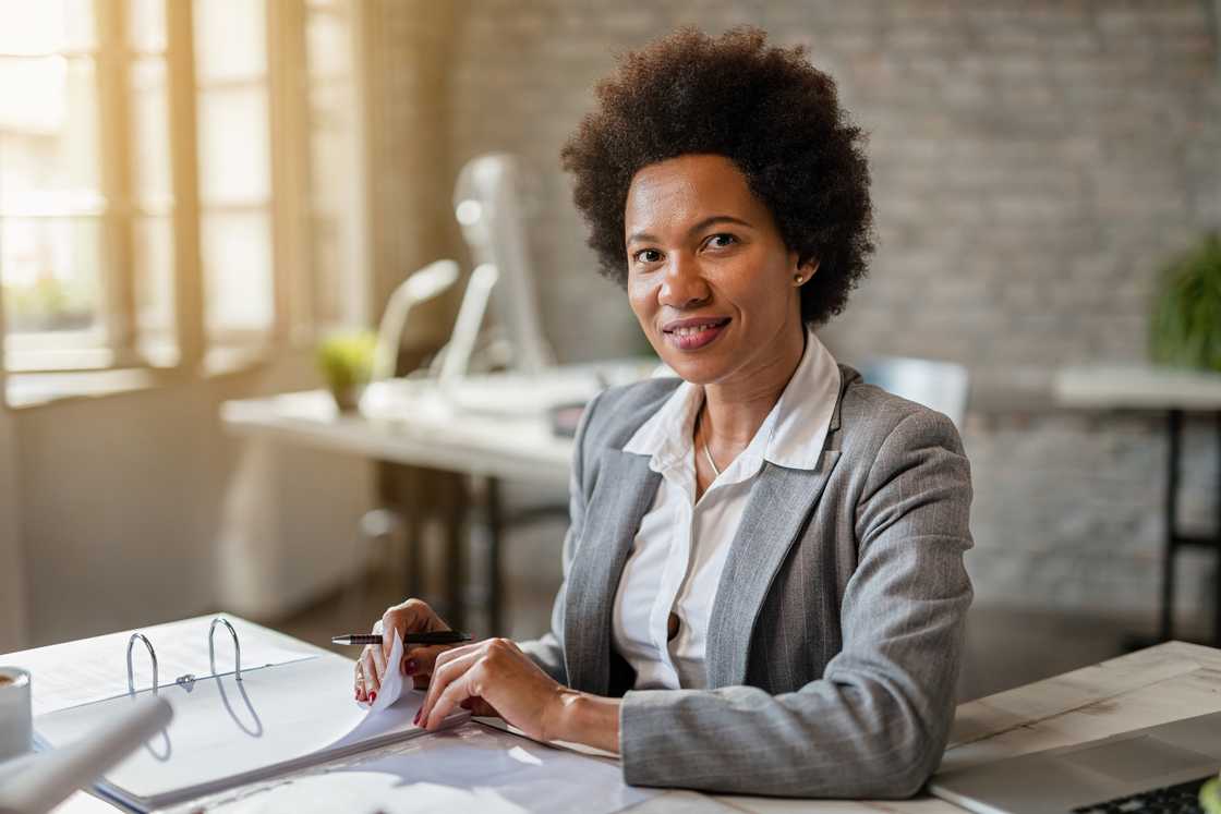 A woman analysing financial reports while working in the office.