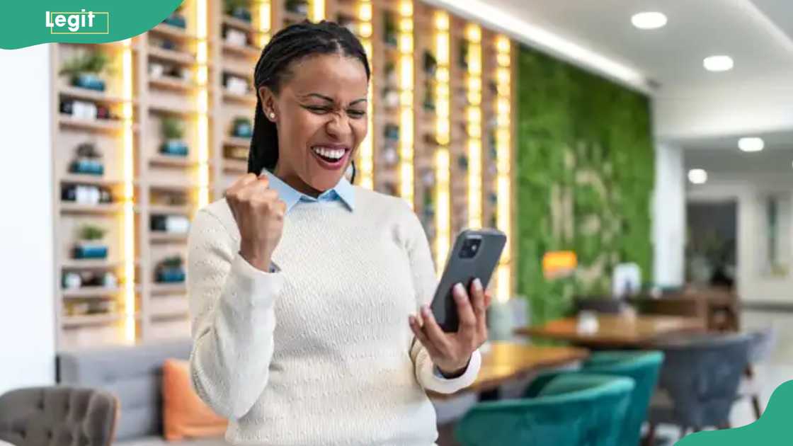 A lady smiles as she looks at her phone A lady smiles as she looks at her phone