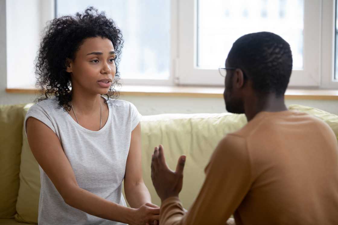A young couple arguing while sitting on the couch