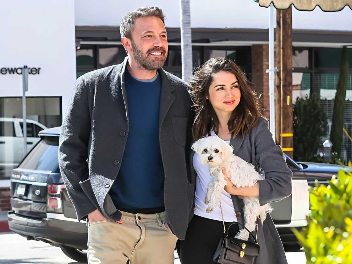 Ana de Armas carries a dog while on a walk with Ben Affleck