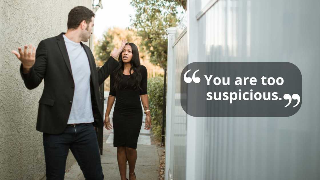 A man and a woman argue while walking along a narrow street.