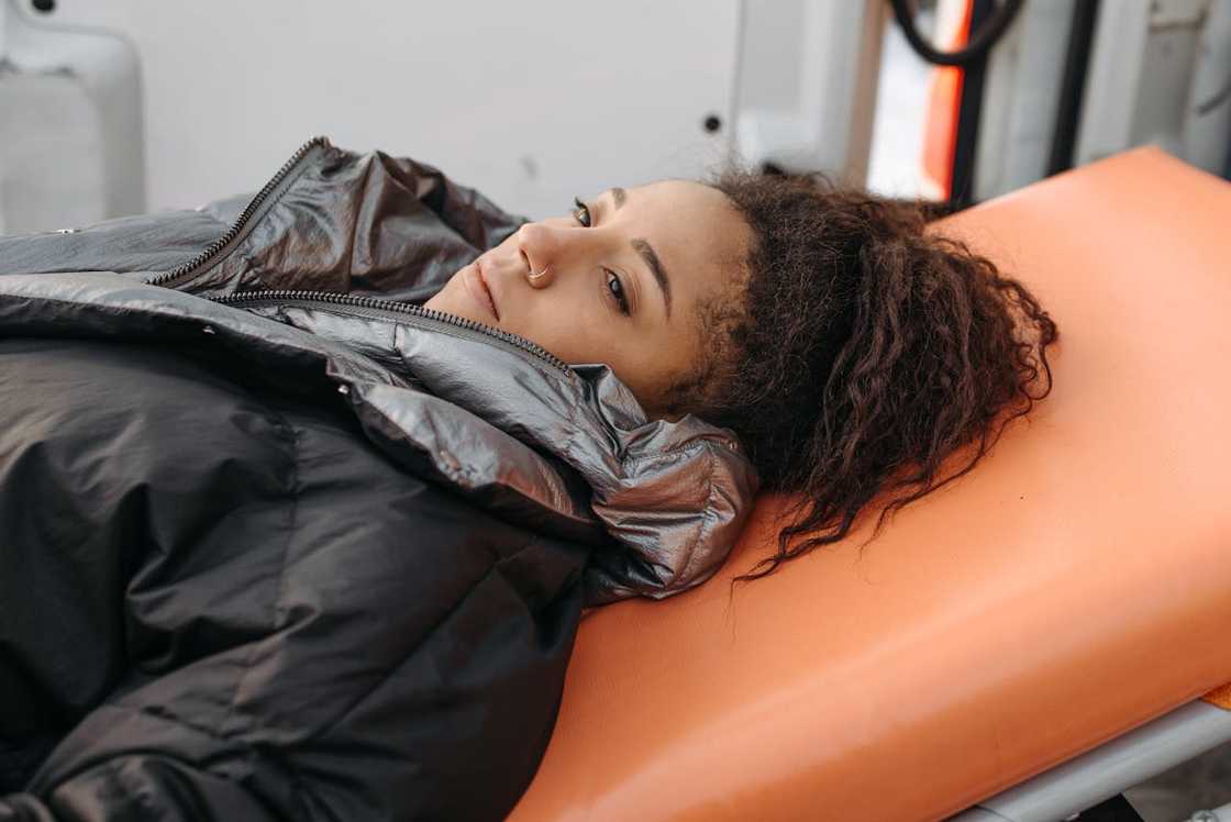 A woman lying on a stretcher, looking foward.