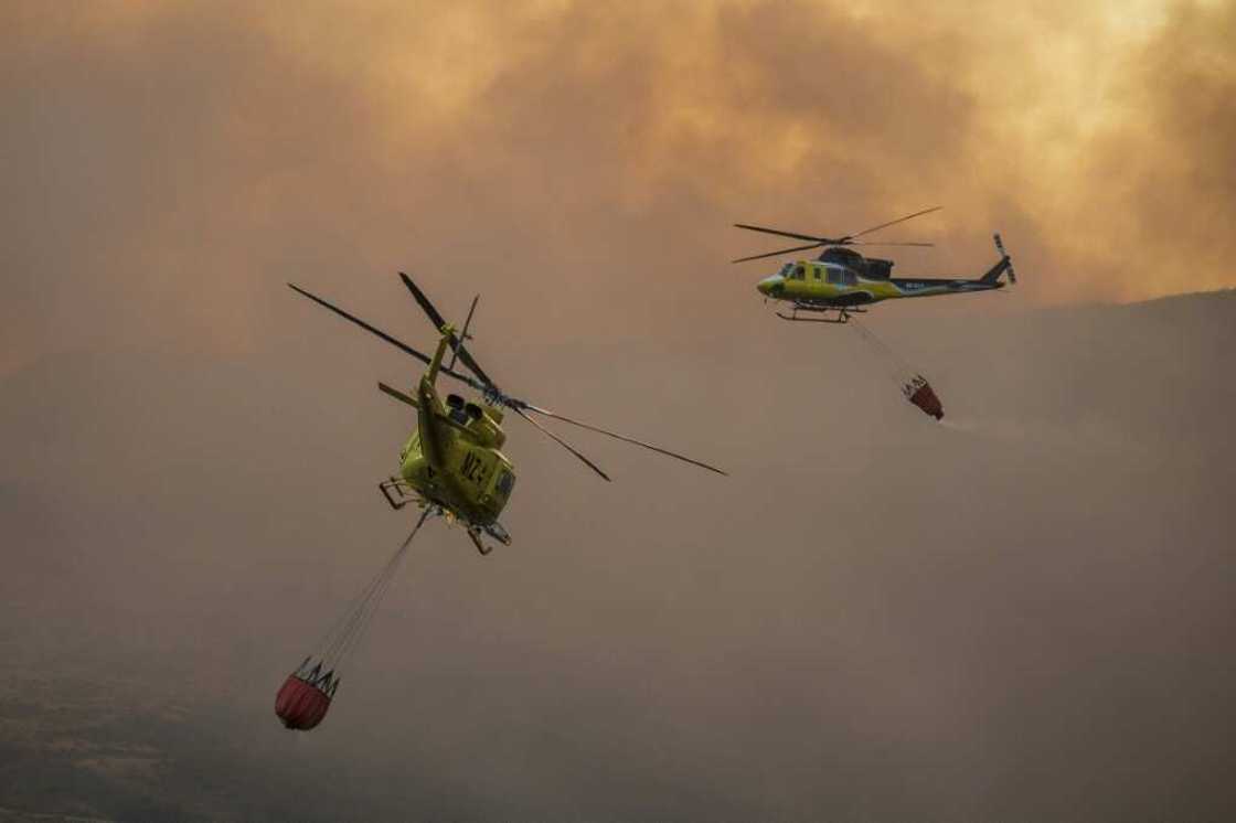 Two firefighter helicopters fly over blaze in a national park in northwestern Spain in late August, amid blistering summer heat. In October, Spain recorded the hottest temperatures for that month since records started in 1961 Two firefighter helicopters fly over blaze in a national park in northwestern Spain in late August, amid blistering summer heat. In October, Spain recorded the hottest temperatures for that month since records started in 1961