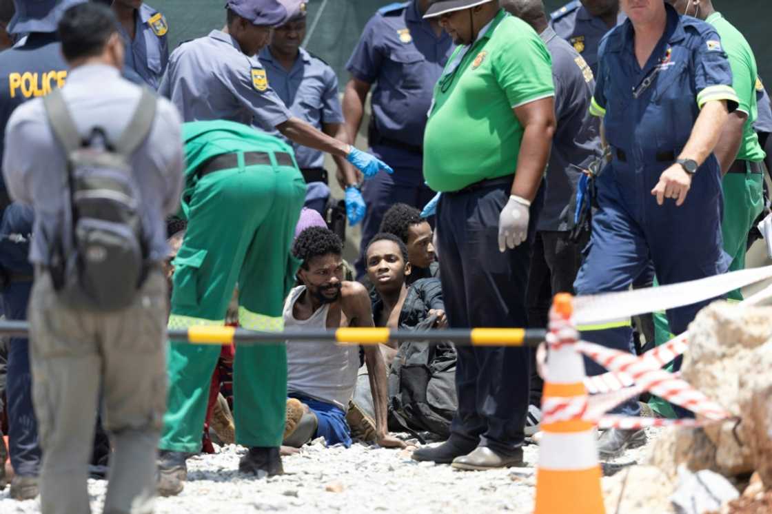 Illegal miners rescued from an abandoned gold mine sit on the floor Illegal miners rescued from an abandoned gold mine sit on the floor