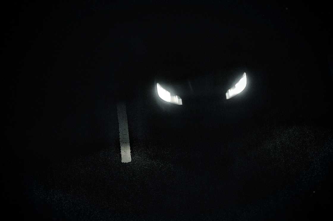 A faint glow of buried headlights in the dark.