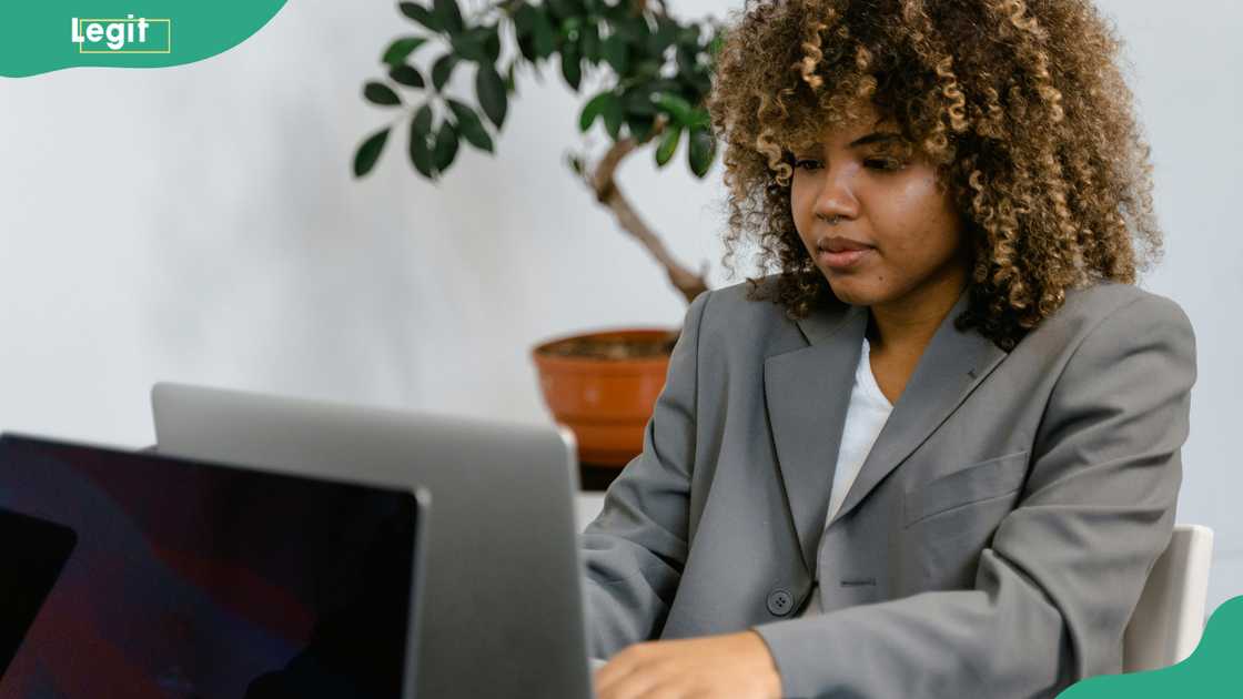 A woman in a grey suit using a laptop