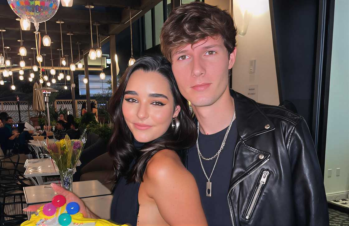 Zach Justice and Indiana Massara standing closely together in a restaurant